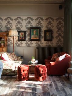 a living room filled with furniture next to a wall mounted radiator and painting