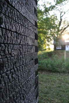 the back side of a building with grass and trees in the background