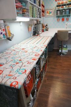 a sewing room with lots of crafting supplies on the counter and shelving units