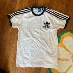 White And Black Adidas Short-Sleeve T-Shirt With The Three Stripes Down The Sleeve. Size M. 100% Cotton Very Clean, Never Worn By Me By It Was Too Small. Approx Laying Flat: -Pit To Pit: 19.25” -Neck Point To Sleeve Edge: 12” -Base Of Neck To Bottom Of Hem: 22” Final Sale. Adidas 3 Stripes Tee, Stripes Tshirt, Black Adidas Shorts, Adidas 3 Stripes, Adidas Tshirt, Adidas Short, Adidas Classic, Adidas T Shirt, Color Cafe