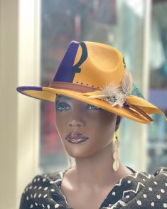 This is modern Western Fedora designer hat . The wild feathers give it a statement look that you can't forget . The felt hat is two tone purple and gold . The hat is hand painted with african prosperity symbols on it . This is a Wow statement . Don't delay order yours today . Yellow Fedora For Kentucky Derby, Multicolor Western Fedora With Curved Brim, Traditional Multicolor Fedora Hat, Adjustable Purple Fedora, Popping Dance, Adjustable Purple Hat With Feathers, Western-themed Fedora With Feather Trim, Western Wide-brim Fedora With Feathers, Modern Western