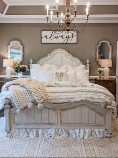 a white bed sitting under a chandelier in a bedroom