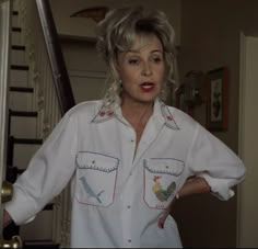 a woman in white shirt standing next to stairs