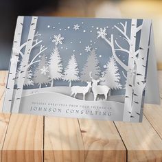 an origami christmas card with two deer in the woods