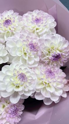 a bunch of white and purple flowers in a vase