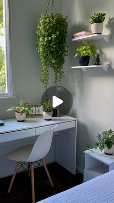 a desk with some plants on it and a window in the backgrounnd