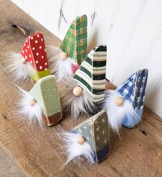 small wooden hats with white feathers and polka dots on them sitting on a wood table