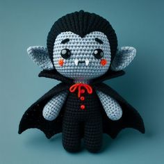 a crocheted dracula doll with red eyes