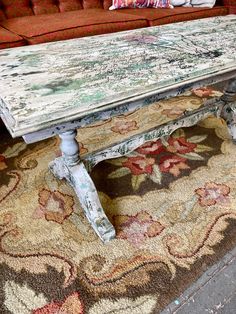 an old wooden table sitting on top of a rug