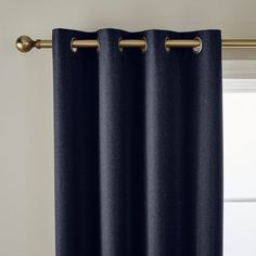 dark blue curtains with gold hardware hanging on a curtain rod