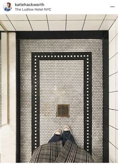 a person laying on top of a bed in a room with tiled walls and floor