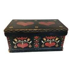 an old wooden box with hearts painted on the lid and sides, sitting against a white background