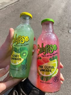 two bottles of pink guacamole and limeade are held in their hands