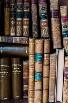 many old books are stacked on top of each other