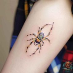 a small spider tattoo on the arm