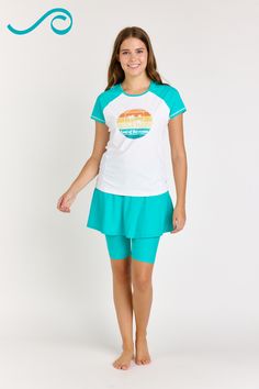 Get ready for the beach in style with the Loose Fit Adele Swim Top With Midi Swim Skort. The loose-fit top features a short sleeve and round neckline for a timeless look, and is super comfortable for a day of sun and fun. The midi swim skort features a wide waistband that sits just below your natural waist and a mid-thigh length skirt with attached shorts. It's flattering on all body types! Shop now and make a splash this summer! Follow Calypsa for more summer beachwear fashion! Green Short Sleeve Swimwear With Stretch, Stretch Short Sleeve Swimwear For Workout, Sporty Swimwear For Summer, Sporty Crew Neck Swimwear For Summer, Summer Compression Short Sleeve Activewear, Fitted White Beach Activewear, Stretch Crew Neck Swimwear For Sports, Sports Swimwear With Crew Neck, Sporty Crew Neck Swimwear For Sports