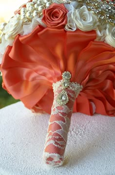 an orange and white bouquet on top of a table next to a cloth covered umbrella