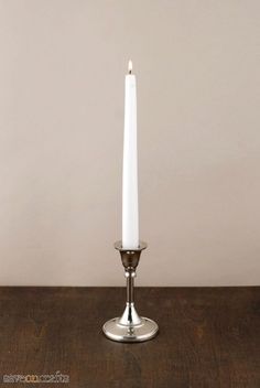 a white candle sitting on top of a wooden table