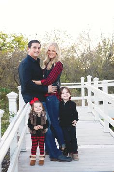 a man and two children standing on a white bridge with their arms around each other