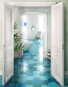 an open door leading to a bathroom with hexagonal tiles on the floor and walls