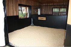 the inside of a horse barn with hay on the floor