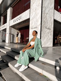 a woman sitting on some steps in front of a building