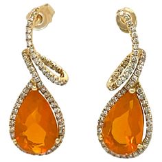 These vibrant 14x8 mm Teardrop Fire Opal and diamond dangling earrings are set in 14 karat yellow gold. They are stunning to wear at that special event. They have a halo of sparkling diamonds and a swirl design for a beautiful accent. These earrings are approximately 1.25" in length and have push back closure. These earrings will be shipped in a beautiful box, ready for the perfect gift! They are brand new with original tags attached. Gold: 3.50 gms 14K yellow Gold Stone: 4.28 ct pear shap Fire Opal, 14x8 mm Diamond: 0.72 cts, 116 round brilliant cut diamonds, Color: H, Clarity: S/I FREE SHIPPING, within the US. Usually ships within 1-2 business days Retail value: $3,750 Mens Diamond Jewelry, Fire Opal Earrings, Swirl Design, Opal Earrings, Sparkle Diamonds, Round Brilliant Cut Diamond, Fire Opal, Diamond Jewelry, Halo