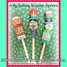 three wooden spoons with painted faces and hats on them, sitting next to each other