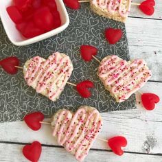 three heart shaped lollipops with sprinkles and hearts on them