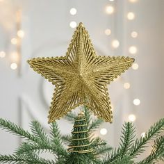 a gold star ornament on top of a christmas tree