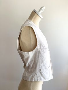 A most perfect crisp white antique cotton vest or top featuring shell buttons and buckle. Pockets and fitted shape. Victorian or Edwardian era in amazing condition. Fabric: CottonFit: S/MEra: 1910's Measurements: Bust 36" Shoulder 14.5" Length 22.5" Waist 31" Condition: Very good. An age spot near the back buckle and some faint rub marks on the back (see photos). Vintage Cotton Vest In Medium Wash, Vintage Cotton Vest With Button Closure, Fitted V-neck Vintage Vest, Vintage Cotton Button-up Denim Vest, Cotton V-neck Vest With Button Closure, Age Spot, Cotton Vest, Shell Buttons, Edwardian Era