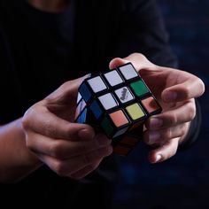 a person holding a rubik cube in their hands