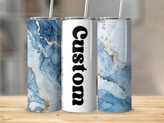 three blue and white canisters sitting on top of a wooden table next to each other