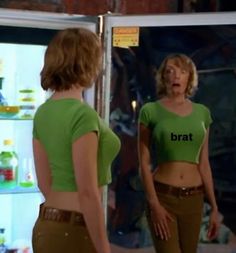 two women standing in front of a refrigerator with the words brat on their shirts