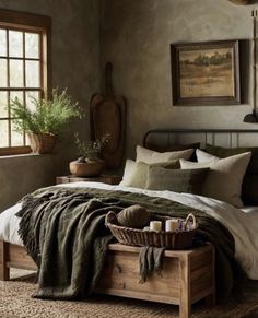 a bedroom with a bed, basket and plants on the table in front of it