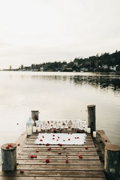 a wooden dock with flowers and candles on it