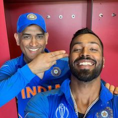 two men in blue shirts are posing for a photo with their hands on each other's shoulders