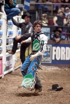 a man riding on the back of a bull in a rodeo