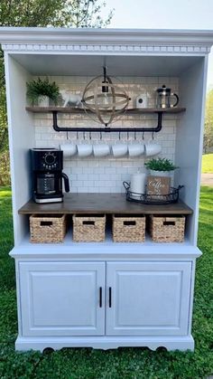 a coffee bar built into the side of a cabinet with baskets and cups on it