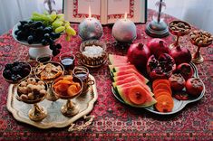 a table topped with lots of different types of fruit and vegetables on plates next to an open book