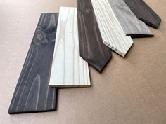 five pieces of wood laying on the floor next to each other, all different colors