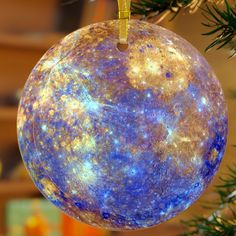 an ornament hanging from a christmas tree decorated with blue and yellow speckles