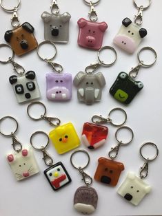 a bunch of key chains that have some animals on them in different colors and shapes