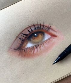 an eye with long lashes is shown next to a pen on a piece of paper