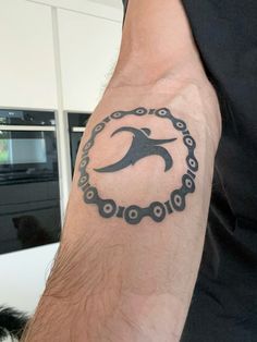 a man's arm with a tattoo on it that has a bird in the middle