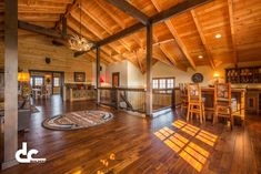 a large open living room with wooden floors and ceiling beams, along with hardwood flooring