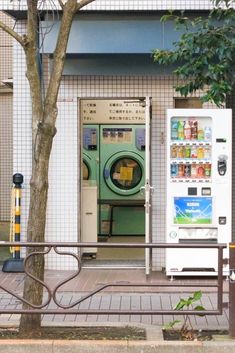 an old washer and dryer sitting on the side of a building next to a tree