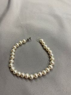 White Freshwater Pearl Bracelet. This bracelet features 28 White Freshwater Pearls AAA round to near round high luster 6.2mm with a heart clasp that is 18K white gold plate over 925 silver. The bracelet is 7 1/2 inches long measured laying flat. I hand knotted this bracelet using spectra thread. I use it instead of silk for my freshwater pearls. It does not stretch, hold oils, or break easily. It can also be gotten wet. I also like the heart clasp, they are easier to connect. We guarantee all of White Pearl Chain Round Bracelets, Formal Round Pearl White Pearl Bracelet, White Round Pearl Bracelet, Elegant Hand-strung Pearl White Bracelet, White Round Hand-strung Pearl Bracelet, White Pearl Bracelet, Aquamarine Pendant, Corpus Christi Tx, Pearl Choker Necklace