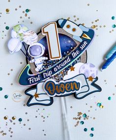 the first trip around the sun cake topper is decorated with blue and gold confetti