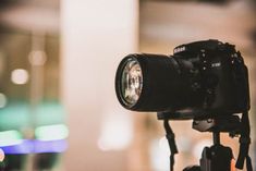 a close up of a camera on a tripod with blurry lights in the background